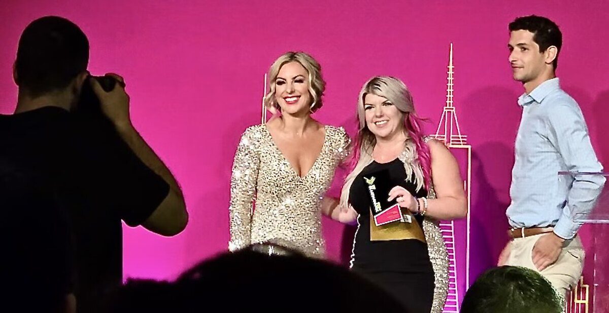 Amanda Friedt accepting an industry award on stage