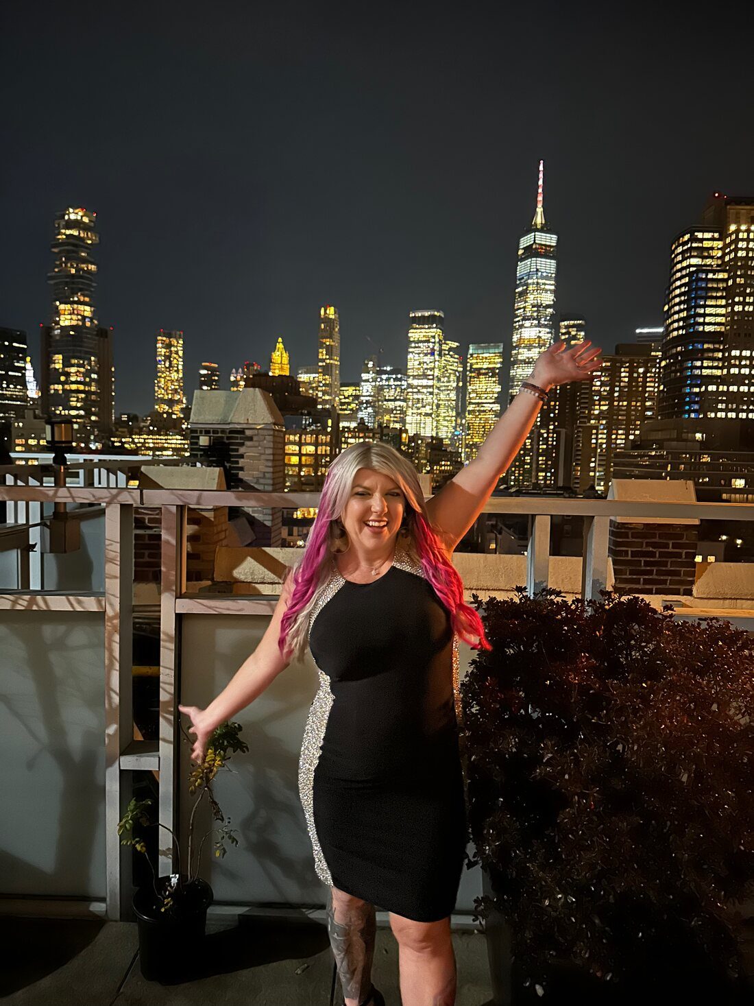 Amanda Friedt on a rooftop with the Manhattan skyline at night
